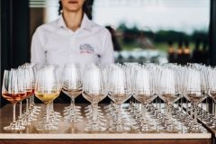 a waiter stands behind a lot of glasses